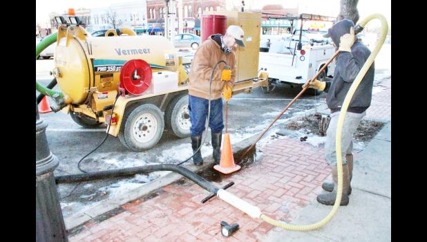 Cliff Givens (left) and P.J. Oldehoeft of Holton’s water and sewer department spent Monday morning, Feb. 22 cleaning out a riser that goes down to a water service line valve on the south side of Holton’s Town Square that was involved in a water line break over the weekend. City water employees and area plumbers noted a significant number of water line breaks due to recent cold weather, it was reported. (Photo by Brian Sanders)