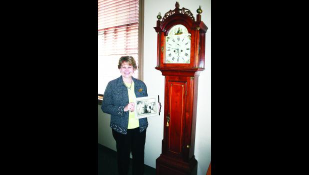 by Brian Sanders Beck-Bookman Library employee Gail Schmitz is shown in the photo above with a grandfather clock that dates back to the early 1800s. The clock was donated to the library by the family of a former librarian, Ellen "Nell" Lowell.