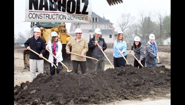 From left to right, Holton USD 336 Board of Education members Steve Bowser, Denise Sweet, Allen Arnold, Bob Phillips, Shelby Patch, Cindy Stavropoulos and Mike Ford turned ceremonial dirt on Wednesday afternoon at the construction site of the new Holton Elementary School, near the existing Colorado Elementary School. Shortly after the groundbreaking ceremony, the old Chandler house that stood behind them at the intersection of Fifth Street and Colorado Avenue was demolished. (Photo by Brian Sanders)
