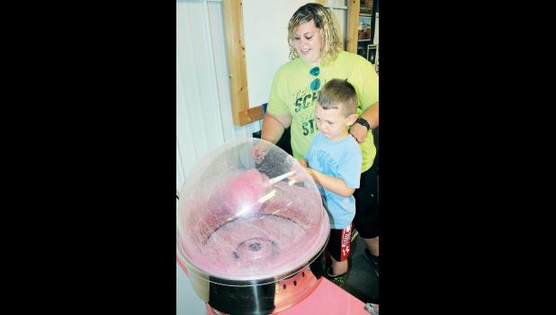 Four-year-old Jackson Kibbee of Holton made some cotton candy recently with the help of Banner Creek Science Center volunteer Holly Wendorff as part of the science center’s “Summer Of Science” promotion. (Photo by Brian Sanders)