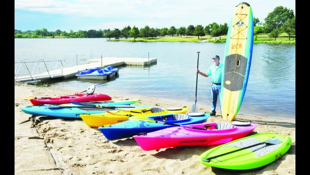 by Ali Holcomb John Kennedy, Banner Creek Reservoir director, is shown above with several paddleboards and kayaks now available to rent at the reservoir. The equipment comes in both adult and youth sizes. In addition, two paddleboats (shown in the background) are available to rent.