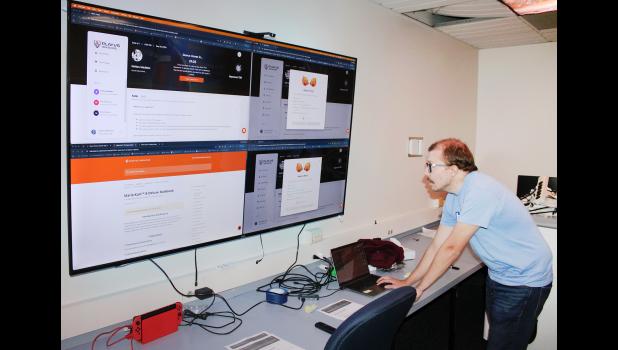 Holton High School e-sports coach Dillon Kathrens checks a monitor to see if other schools' e-sports teams are ready for practice games with members of his team. Kathrens said his team competes with other schools from all across the country. (Photo by Brian Sanders)