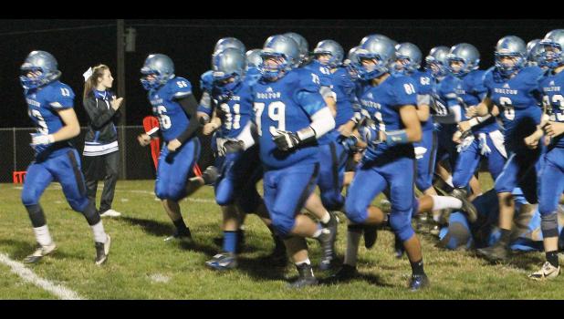 By Kelly Breckunitch Linebacker Jordan Booth (shown above, left) leads the Wildcats onto the field as they prepare to open the Class 4A-DII playoffs against the Trojans of Osawatomie.