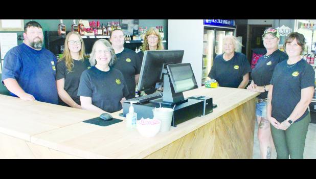 Dennis Edmonds (shown above at far left) recently opened the Shine Runners liquor store at 204 Arizona Ave. Store employees, shown from left in the photo above, include Edmonds, Sarah Edmonds, Mary Teeter, Madeline Montgomery, Barbara Mattox, Otha Robinson, Jessie Robinson and Megan Montgomery.           