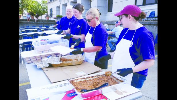 GNBank employees (from left) Jim Klingler, Audrey Kimmi, Theresa Rodecap and Kyrianna Hielscher are shown assembling the meal, which included pulled pork sandwiches, beans, chips and a drink.   