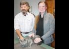 Holton veterinarian Dan Degenhardt (left) of Banner Creek Animal Hospital has announced that he will retire at the end of April after nearly four decades of practicing veterinary medicine. The clinic’s new owner is veterinarian Taylor Kennedy (right), who joined the clinic staff in 2018. Degenhardt and Kennedy are shown above with “clinic cat” Ringo. (Photo by Brian Sanders)