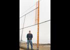 Holton Parks and Recreation Director Mike Reichle stands next to a 16-foot section of chain link fence in right field at Optimist Field in Holton’s Chandler Park. New fencing has recently been installed at the baseball field. (Photo by Brian Sanders)
