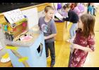 First, second and fourth-grade students at Royal Valley Elementary School had the opportunity to play arcade games created by third-graders at school to earn tickets for a chance to win several prizes. Here, third-grader Gannon Herbers (left) is shown explaining his arcade game, “Lighty Brighty,” to first-grader Korianna Ribelin. (Photo by Ali Holcomb)