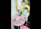 Four-year-old Jackson Kibbee of Holton made some cotton candy recently with the help of Banner Creek Science Center volunteer Holly Wendorff as part of the science center’s “Summer Of Science” promotion. (Photo by Brian Sanders)