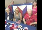Local military veterans Dorothy Rogers (at left on front row) and Charles Scheidegger (at right on front row) were among 50 veterans honored at the second-annual Quilts of Valor event on Saturday. Organizers Julie Bahret (rear left) and Connie Morgan (rear right) helped organize the dinner and presentation. Also shown is Rogers’ daughter, Jackie Sommers of Topeka. More than 300 dinners were served at the event. (Photo by David Powls)
