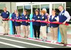 Holton saw the opening of a new Walmart store this morning with the ceremonial ribbon-cutting signaling the first day of business at the new, 24-hour store. Shown from left are Walmart employees Bob Basel, Michele Bloom, Dianna Beatty, Lisa Lehmkuhl, Lorrie Proctor, Cheryl Henry, Clara Lovvorn, Janet Corning and store manager Cale Worthington. At 70,000 square feet, the new store is nearly double the size of the old 38,000-square-foot store, Worthington said.