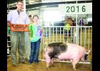 Cassandra Fund (right) took home grand champion market hog honors with her crossbred market hog during the Jackson County Swine Show on Tuesday. Fund is pictured with judge Zach McCracken.