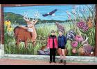 As part of her recent visit to Holton, Kansas Gov. Laura Kelly (at left) stopped by the recently completed mural on the north side of the Jackson County Museum painted by Lindsey Kernodle (at right) of Wichita. The mural depicts a variety of animals and vegetation native to the eastern tall grass prairie. (Photo by Ali Holcomb)