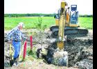 Holton Water and Wastewater Superintendent Dennis Ashcraft (left) watched as Monte McDaniel of Tonganoxie's Kansas Heavy Construction dug out a trench at the Holton Industrial Park so that Ashcraft and others from his department could remove an old waterline in preparation for KHC's work on rebuilding the roads in the industrial park. Justin Wensel, project manager for KHC, said it is likely that road work in the park will begin sometime next week.