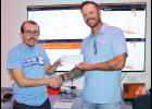 Holton High School e-sports coach Dillon Kathrens (at left) recently received a $5,044.72 donation from Giant Communications general manager Austin Taylor (at right) for the e-sports program at HHS. (Photo by Brian Sanders)