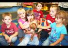 Bella (center), a Yorkshire terrier, has found a place in the early childhood special education class at Jackson Heights Elementary School, along with students (from left) Kaleb Dierking, Maggie Wichman, Emma Bellinghausen, Owen Shughart, Brandin Fritz and London Edwards.	(Photo by Brian Sanders)