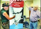Area veterans Les Crawshaw (shown above at left) and Mike Wilson hold up an example of a three-foot by five-foot patriotic banner from the Garnett community Monday evening at the Holton City Commission meeting.