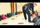 Jackson County Sheriff Deputy Travis DeBarge and his K-9 partner, Benny, are shown above searching school bags placed in the lower hallway at Royal Valley High School on Thursday. The drug dog searches are conducted at the school and the parking lot two to three times a year. (Photo by Ali Holcomb)