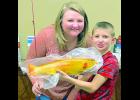 Falcon Robb of Delia (at right) is shown after catching a golden trout at Holton’s Elkhorn Lake. For catching a golden trout, Robb received several items from Holton Parks and Recreation, as well as “Chamber Bucks” from Ashlee York (at left), Holton/Jackson County Chamber of Commerce director. 