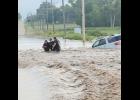 Three people were rescued from floodwaters in Jackson County early Friday morning following heavy rains. In this photo, Holton Police Officers Chad Ballenger (center) and Justin Keller (at right) are shown helping an unnamed flood victim navigate floodwaters after her vehicle was swept off Q.4 Road just north of Holton near Elk Creek. (Photo courtesy of Holton Police Department)