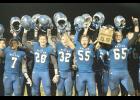 Holton's Brandon Lehnherr (65) and Parker Zeller (55) hoist up the Sectional trophy after the 32-28 win over Frontenac. Other players pictured are: Tyler Price (32), Spencer Baum (28) and Miles McClintock-Strozier (7).