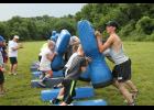 Holton coaches shown above at left, left to right, Brad Weilert and Mark Middlemist, encourage several Junior Wildcats as they fire off and push against blocking dummies at the recent football camp here.